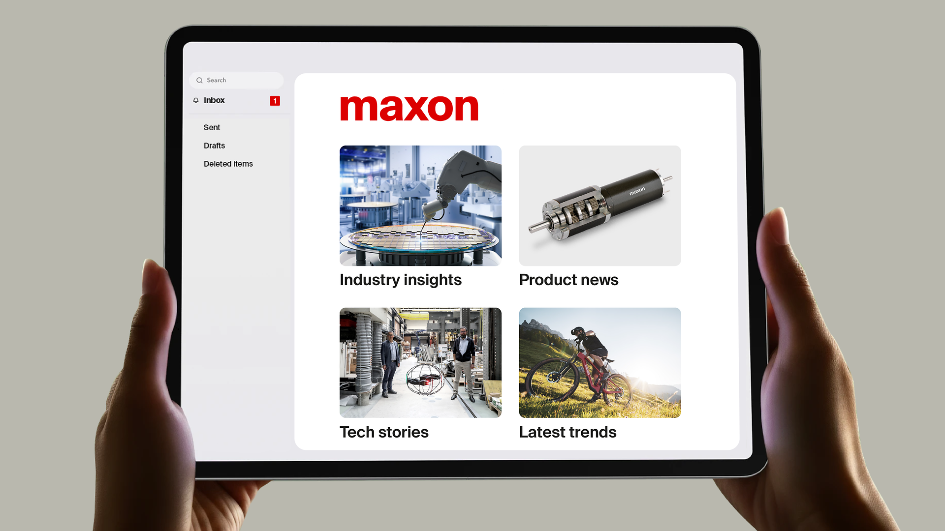 Hands holding a tablet displaying the maxon mail interface